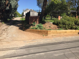 This dirt hill sloped to the point where it came down to the street. We  cut into the hill and built the timbers in a way as to contain the dirt from intruding onto the street. This made the street wider for parking and made it clean cut.